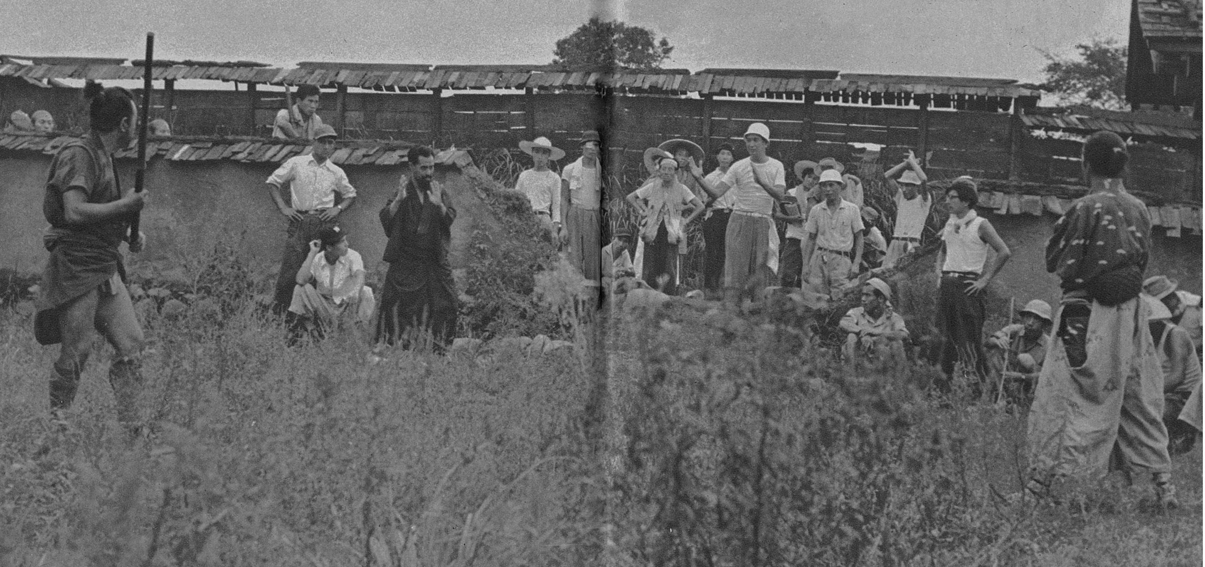 Sugino Sensei on the set of Seven Samurai choreographing the pivotal fight scene between the braggart and Kyūzō, the stone-faced samurai. Director Kurosawa (to the right) is dressed in white hat and white T-shirt.